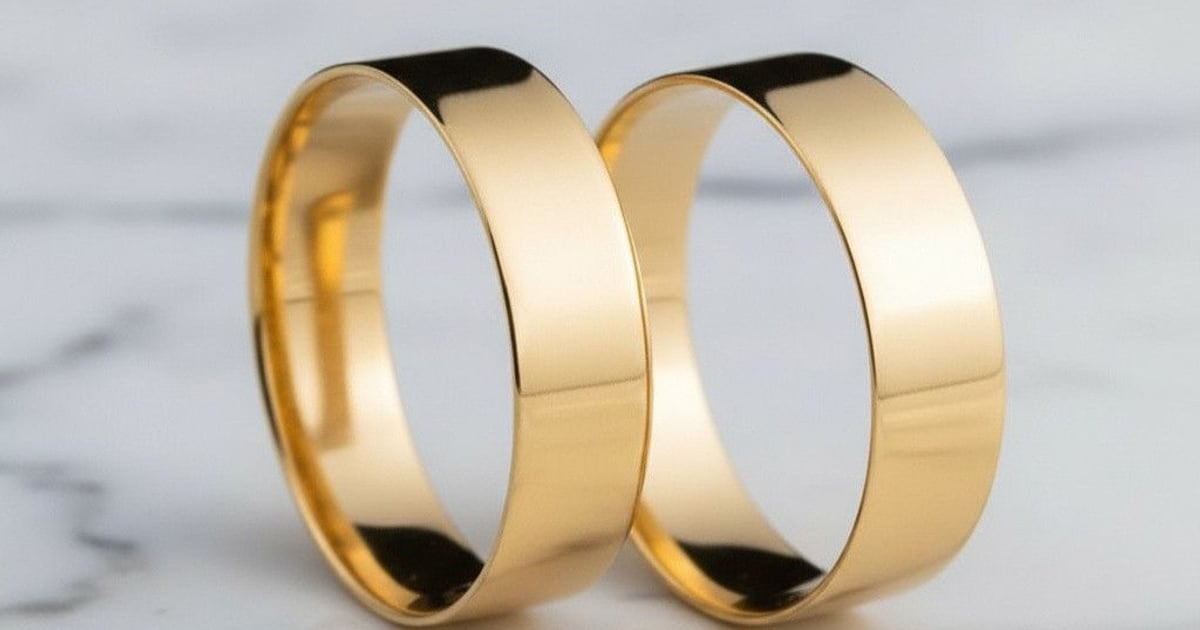 Par de alianças de casamento em ouro amarelo polido sobre mármore branco